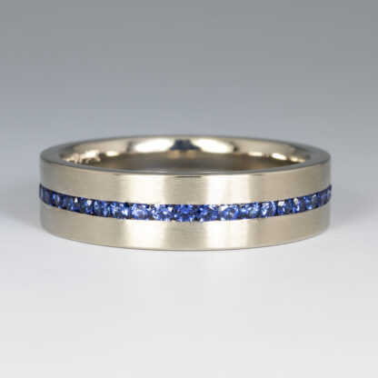 Wedding band, 5.5mm flat comfort fit band with (45) .75ctw. 1.5mm blue sapphires (round brilliant cut from Madagascar) channel set all around, size 8.75, 14KW